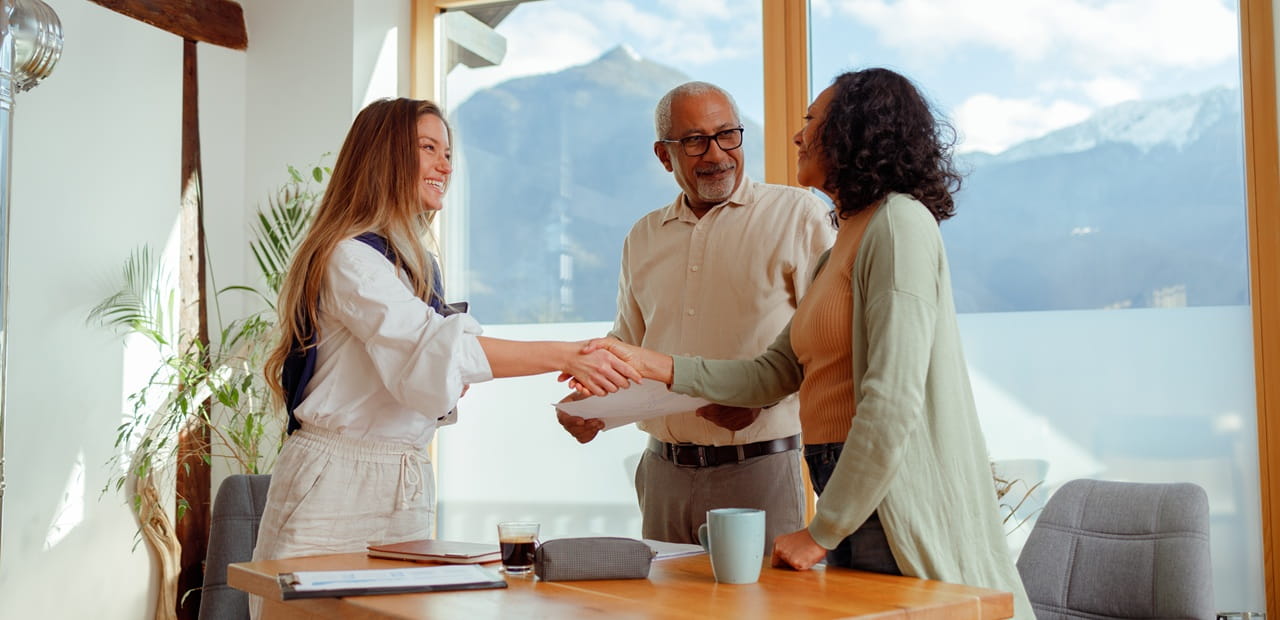 A financial professional meeting with two investors to discuss social enterprise investments that align financial goals with meaningful causes.
