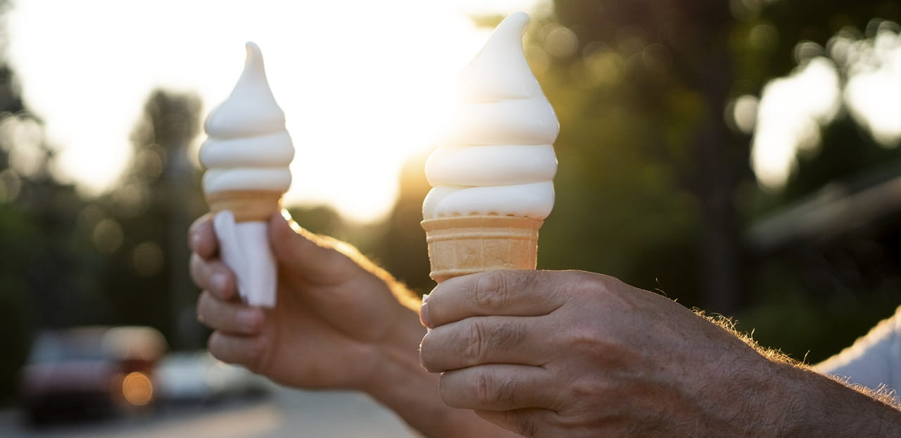 Two retirees holding ice cream cones outdoors at sunset, reflecting how enjoying simple moments and meaningful experiences can contribute to a fulfilling retirement beyond financial security.