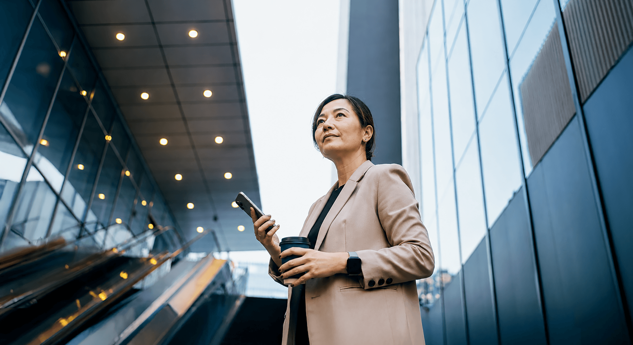 Professional businesswoman standing against modern financial skyscrapers